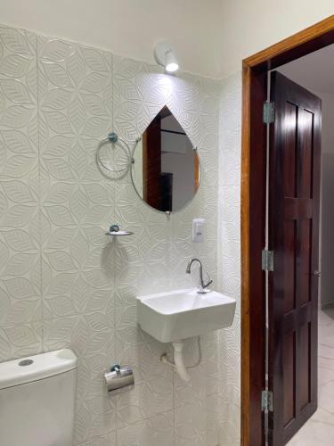 a bathroom with a sink and a toilet and a mirror at Residence Brisa in Jericoacoara