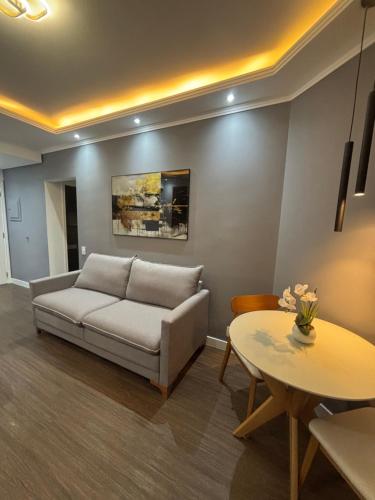 a living room with a couch and a table at Flat Premium -Acesso a pé ao shopping Center vale - Edifício Summit (Ar condicionado) in São José dos Campos