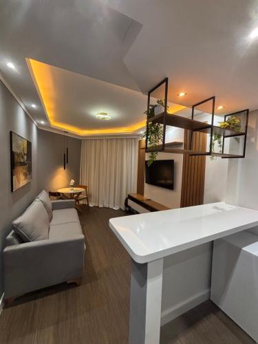 a living room with a couch and a table at Flat Premium -Acesso a pé ao shopping Center vale - Edifício Summit (Ar condicionado) in São José dos Campos