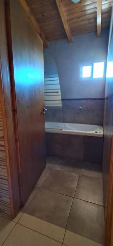 a bathroom with a door and a window and a bench at Departamento OHANA in Malargüe