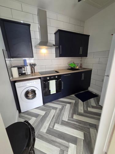 a small kitchen with a washer and dryer in it at Spacious New Studio in Blackburn Town Centre in Blackburn