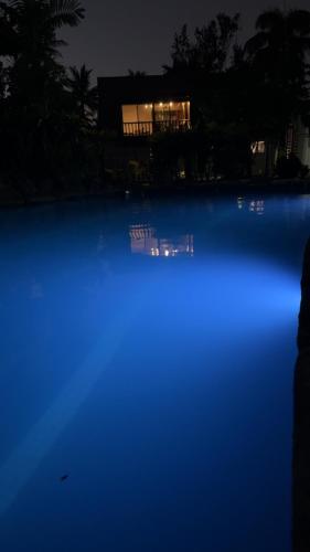 a pool of blue water with a house in the background at MIRZ Accomodation in Pacific Harbour