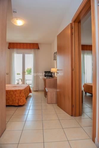 a bedroom with a bed and a desk in a room at Pellegrino Palace Hotel in Vieste
