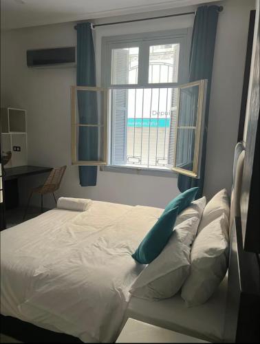 a bed in a bedroom with a window at Tingis Concept in Tangier