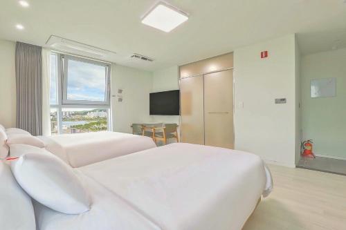 a hotel room with two beds and a television at Berith Hotel in Sokcho