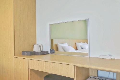 a mirror on a desk with a bed in a room at Berith Hotel in Sokcho