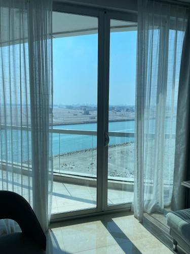 a room with a large window with a view of the ocean at cozy sea view one bedroom apartment in Dilmunia Island