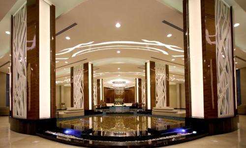 a hotel lobby with a large hall with a fountain at cozy sea view one bedroom apartment in Dilmunia Island