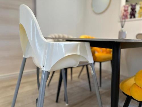 two white chairs sitting next to a dining room table at 最大19人一棟貸切4Bed rooms福島 in Osaka