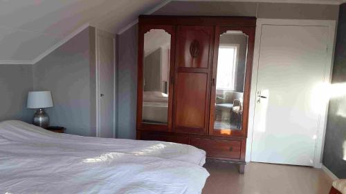 a bedroom with a bed and a wooden cabinet at Norra Värmlands paradis in Sunnemo
