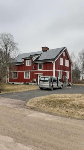 a van parked in front of a red barn at Norra Värmlands paradis in Sunnemo