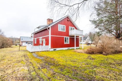 a red barn sitting on top of a field at Norra Värmlands paradis in Sunnemo