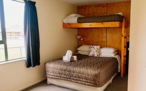a bedroom with two bunk beds and a small bed at Snow Denn Lodge in Methven