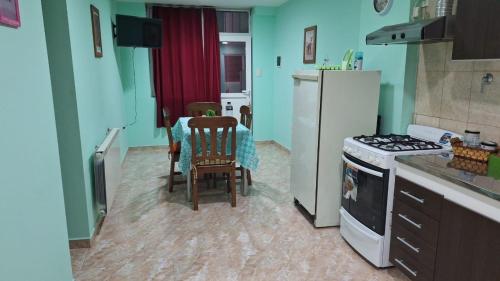 a kitchen with a table and a white refrigerator at Departamento Dulce Adelina I - Zona Céntrica in Río Grande