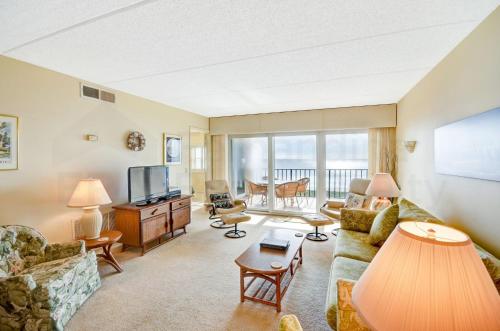 a living room with a couch and a television at Oceanview Amelia South Condo in Fernandina Beach