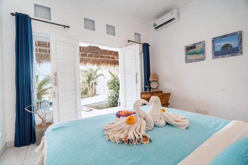 two swans sitting on a bed in a bedroom at Sukacita Hill in Uluwatu