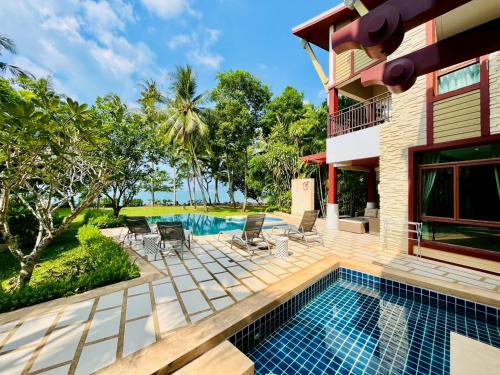 a villa with a swimming pool and a house at Amatapura Beachfront Villa 12, SHA Certified in Ao Nam Mao