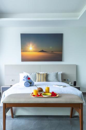 a bedroom with a bed with a tray of food on it at Solmare Apartments & Suites in Akumal