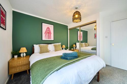 a bedroom with a large bed and a green wall at 2 Bedroom Gardens Retreat with Free Parking in Glasgow