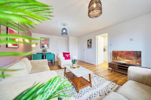 a living room with a couch and a tv at 2BR Flat with Free Parking in Central Location in Glasgow