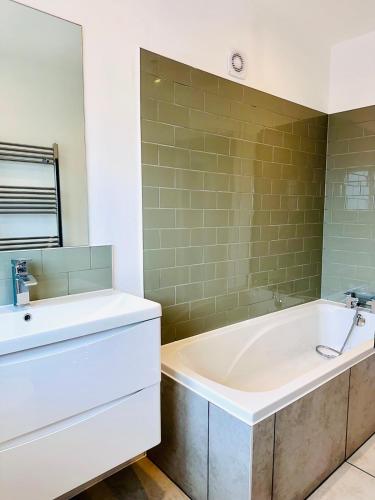 a bathroom with a tub and a sink at Serene Stays in Coulsdon