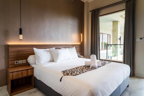 ein Schlafzimmer mit einem großen weißen Bett und einem Fenster in der Unterkunft Ayers Hotel&Resto in Saba