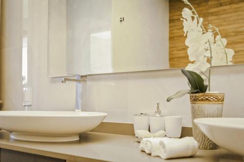 a white bathroom with two sinks and a mirror at Solmare Apartments & Suites in Akumal