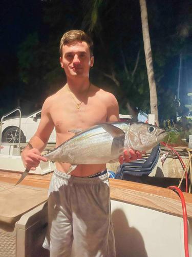 a man is holding a fish in his hand at Keys Livin - Yacht Rental in Key West