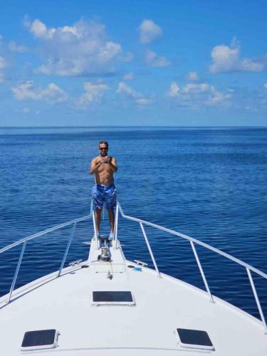 a man standing on the front of a boat in the ocean at Keys Livin - Yacht Rental in Key West