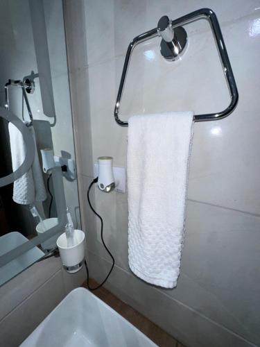 a bathroom with a white towel hanging from a mirror at Brand New Beachfront Sunset Apartments in San Felipe de Puerto Plata