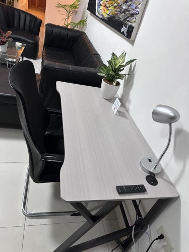 a desk with a chair and a lamp on it at Brand New Beachfront Sunset Apartments in San Felipe de Puerto Plata