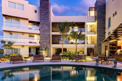 an exterior view of a building with a swimming pool at Solmare Apartments & Suites in Akumal
