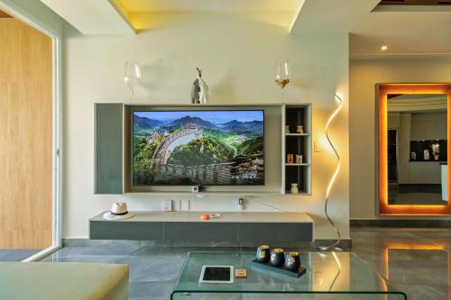 a living room with a flat screen tv on the wall at Solmare Apartments & Suites in Akumal
