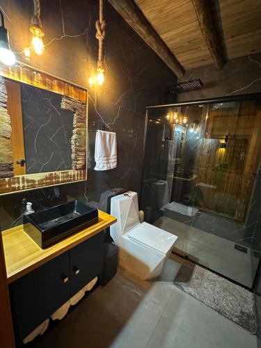 a bathroom with a sink and a toilet and a shower at Garden Guest House Garopaba in Garopaba