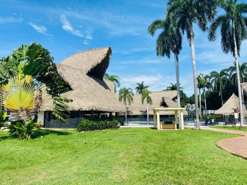 a resort with a thatched roof and a pool at Apartamento Campestre con Confort y Exclusividad in Flandes