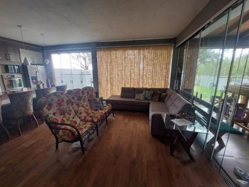 a living room with a couch and a table at Casa da lagoa com rampa para embarcações in Tramandaí