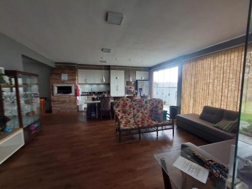 a large living room with a couch and a kitchen at Casa da lagoa com rampa para embarcações in Tramandaí
