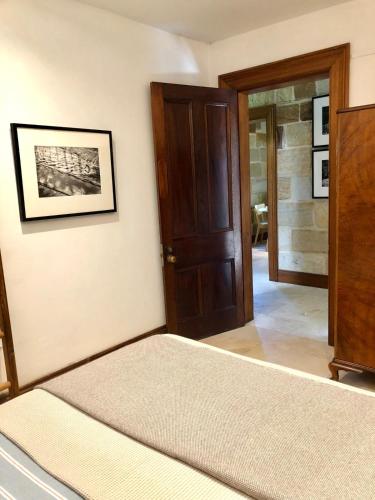 a bedroom with a bed and a wooden door at Stone 1Bedroom Cottage in Sydney