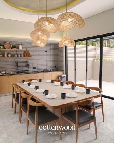 a large dining room table with chairs and chandeliers at Cottonwood Casarean Layar300inch Heated-Pool Billyard Api-Unggun in Tegalharendong