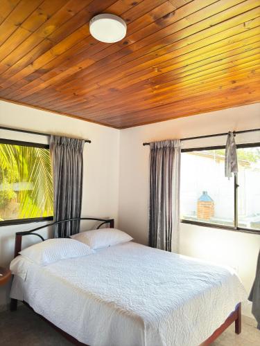 a bedroom with a bed with a wooden ceiling at House Villa Las Marias in Juan de Acosta