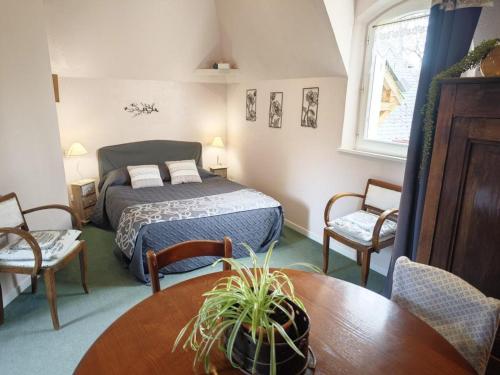 une chambre avec un lit, une table et des chaises dans l'établissement Évasion Romantique: Charmant Gîte 2 Pers., Parc Boisé, Activités & Confort Tout Inclus - FR-1-381-455, à Souvigny-de-Touraine