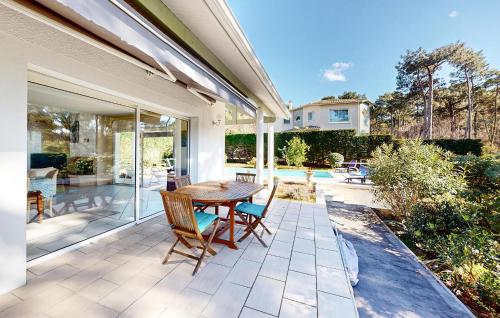 un patio extérieur avec une table et des chaises en bois dans l'établissement Cozy Home In Arcachon With Wifi, à Arcachon