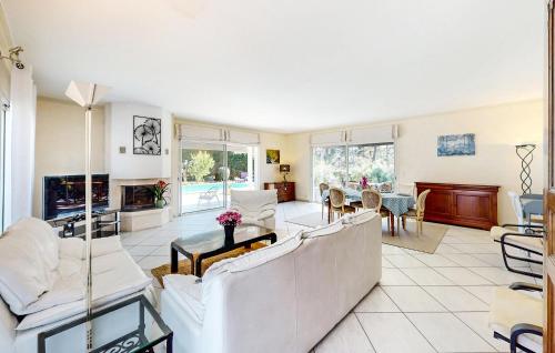 Elle comprend un salon doté d'un mobilier blanc et d'une cheminée. dans l'établissement Cozy Home In Arcachon With Wifi, à Arcachon