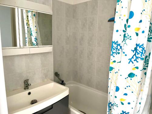 une salle de bain avec un lavabo et un rideau de douche dans l'établissement Appartement 2 pièces à Sète, 500m de la plage, terrasse, parking, animaux admis - FR-1-338-336, à Sète