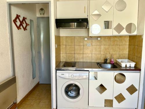 une cuisine avec une machine à laver et un évier dans l'établissement Appartement 2 pièces à Sète, 500m de la plage, terrasse, parking, animaux admis - FR-1-338-336, à Sète