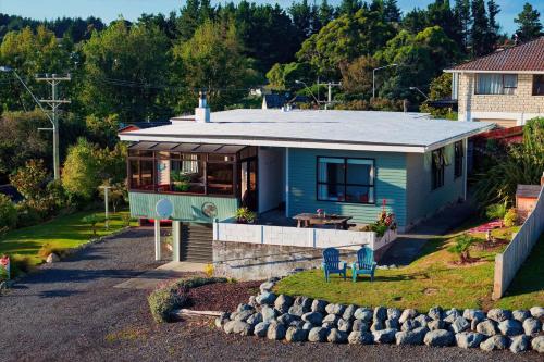 a small blue house with a lot of windows at Classic Charm Sea & Mountain Views in Kaikoura