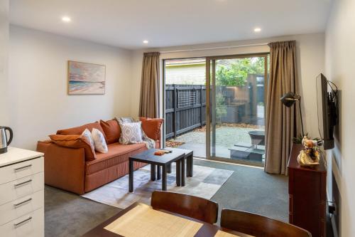 a living room with a couch and a table at Bright & Spacious 2BR near Ara Institute and CBD in Christchurch