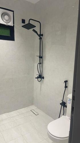 a bathroom with a white toilet and a shower at Bedroom Apartment S10 in Al Kharj