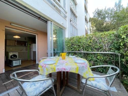 une table et des chaises avec une nappe sur une terrasse dans l'établissement Appartement T2 cabine avec terrasse et parking sécurisé à Sète - FR-1-338-402, à Sète