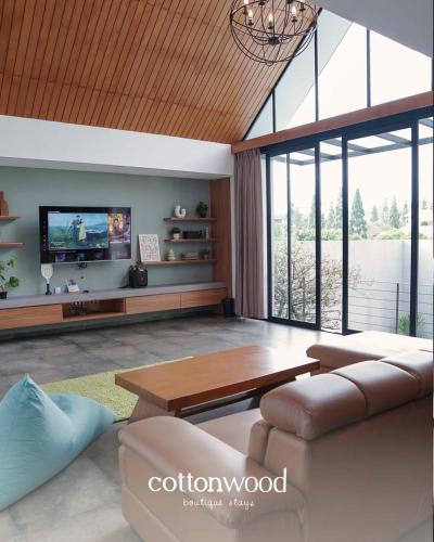 ein Wohnzimmer mit Sofa und Fernseher in der Unterkunft Cottonwood Villa Pavana - Heated pool Fitness LayarTancep200inch in Bandung